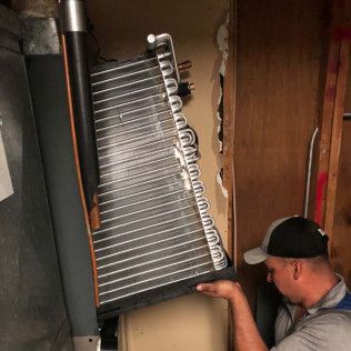 Inspecting an HVAC unit to see if it needs to be repaired.